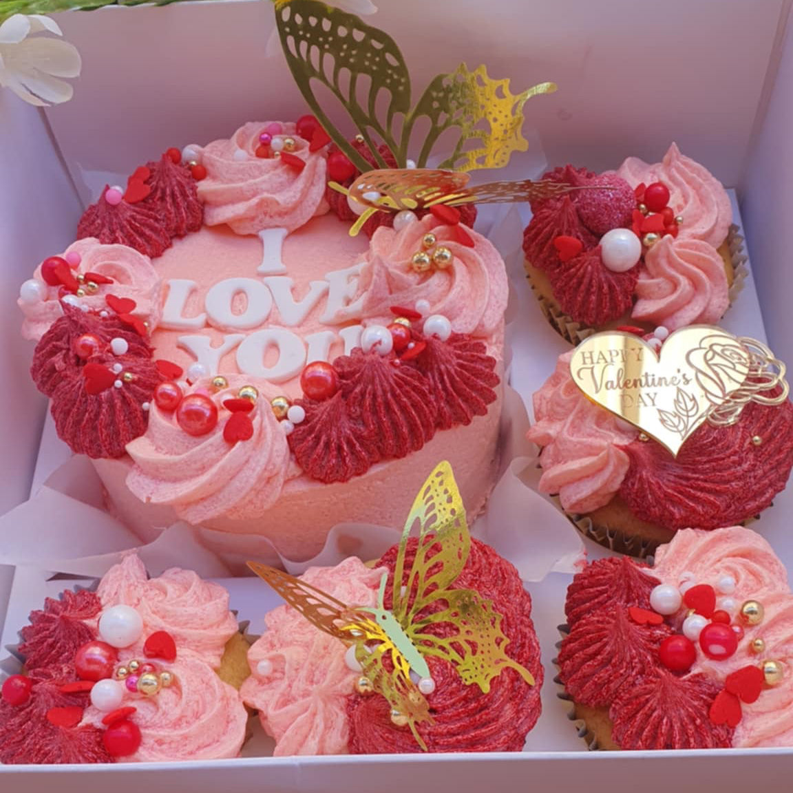 Valentine's Day Cake Bento Box with 'I Love You' cupcakes, colorful butterflies, pink and red sprinkles, and a 'Happy Valentine's Day' message.
